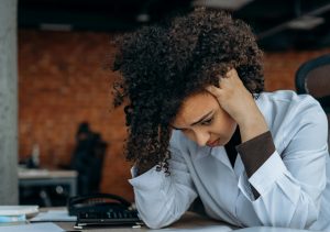 woman sitting behind a desk dealing with burnout