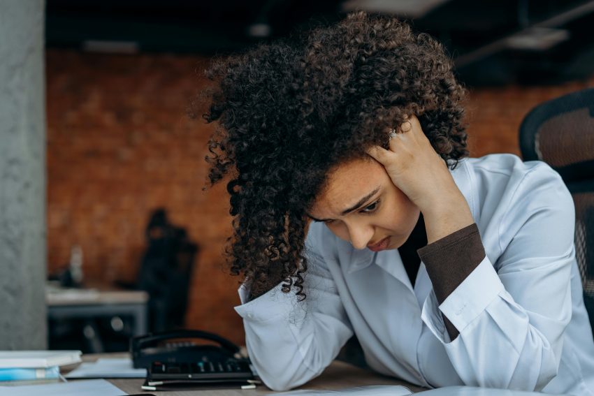 woman sitting behind a desk dealing with burnout